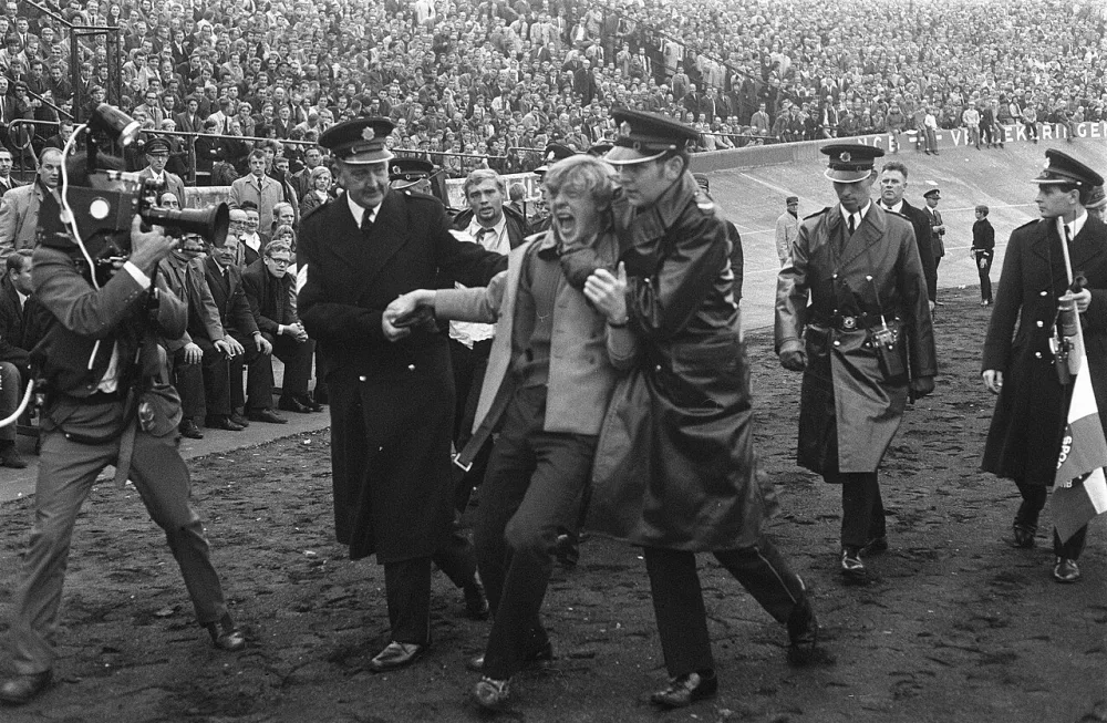 NEC tegen Feyenoord 0-2. Politie-agenten verwijderen supporter. Foto: Eric Koch / Anefo, Nationaal Archief (CC0).