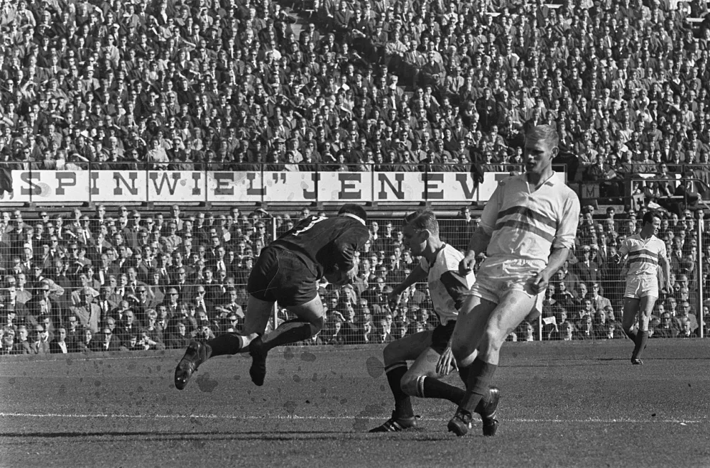 Speler Venneker tijdens een duel met keeper Vogels, rechts Benen (Fortuna 54). Foto: fotograaf onbekend / Anefo, Nationaal Archief (CC0).
