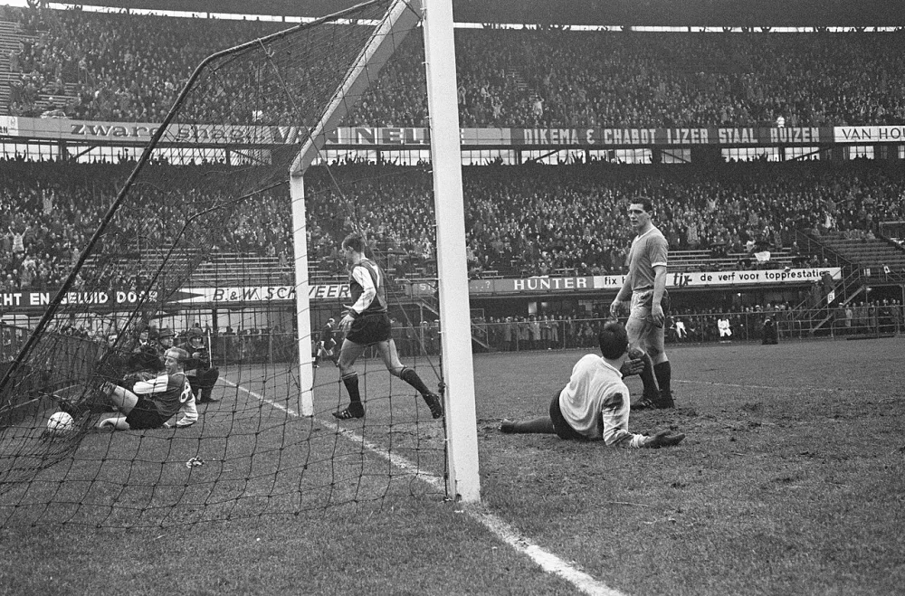 Feyenoord tegen Fortuna 54 5-0, Henk Groot met bal i doel, rechts Venneker op grond keeper Vogels naast hem Van der Hart. Foto: Eric Koch / Anefo, Nationaal Archief (CC0).