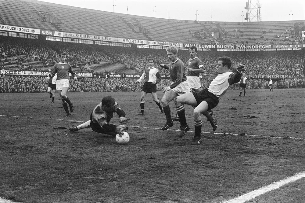 Feyenoord speler Rinus Israël lost een schot op keeper Van Leeuwen, links Ove Kindvall. Foto: fotograaf onbekend / Anefo, Nationaal Archief (CC0).