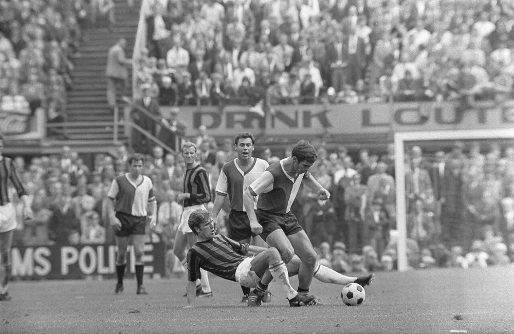 Feyenoord tegen DWS 3-2, Van Hanegem wordt in de schaar genomen door Overweg; daarachter, Israél, Nuninga (DWS) en Hasil. Foto: Eric Koch / Anefo, Nationaal Archief (CC0).