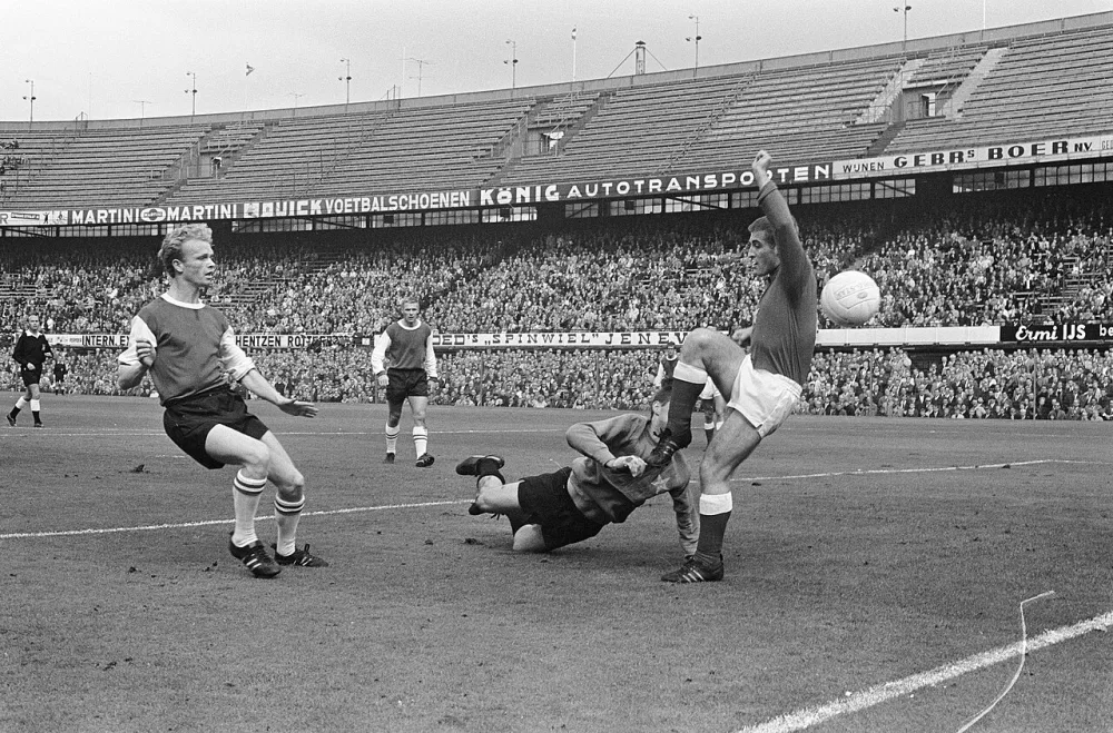 Fyenoord speler Ruud Geels (l) scoort de eerste goal tegen MVV, in het midden keeper Frans Körver. Foto: fotograaf onbekend / Anefo, Nationaal Archief (CC0).