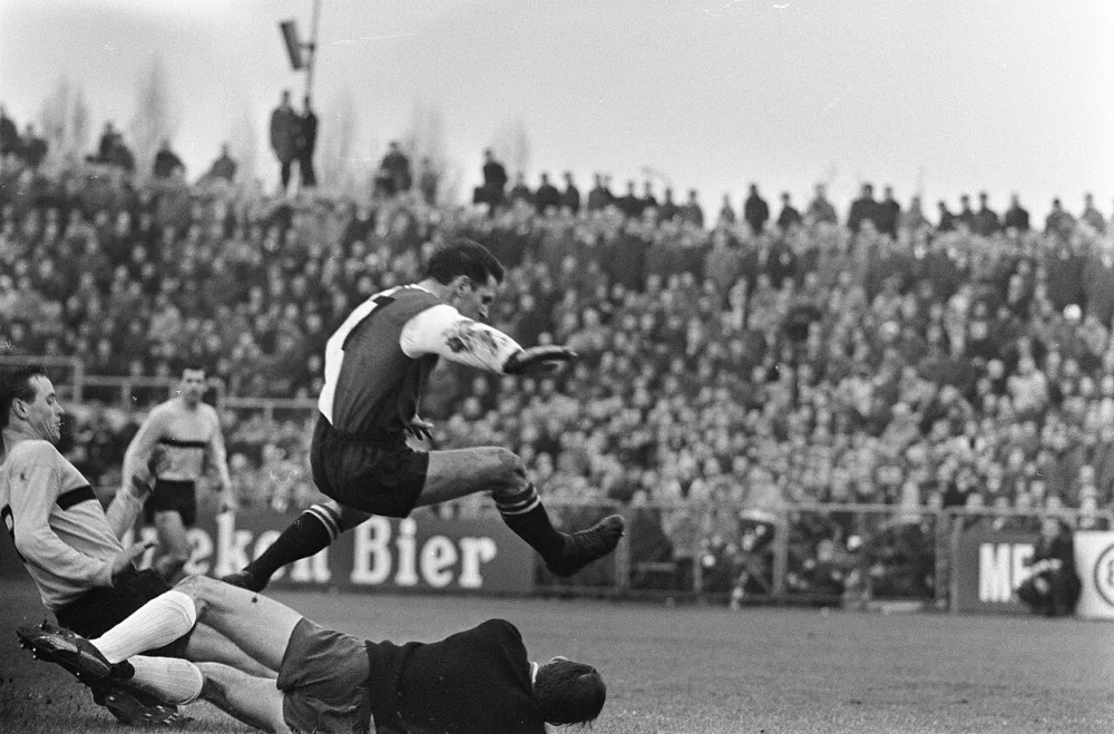 Voetbalwedstrijd DOS - Feyenoord 0-3 te Utrecht; keeper Ruitenbeek (DOS) in duel met Henny Weering (Feyenoord). Foto: fotograaf onbekend / Anefo, Nationaal Archief (CC0).