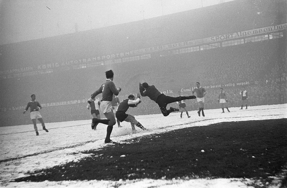 Feyenoord tegen Fortuna 54 . Keeper Vogels van Fortuna springt hoog op voor de aanstormende Gerard 'Pummie' Bergholtz. Foto: Eric Koch / Anefo, Nationaal Archief (CC0).