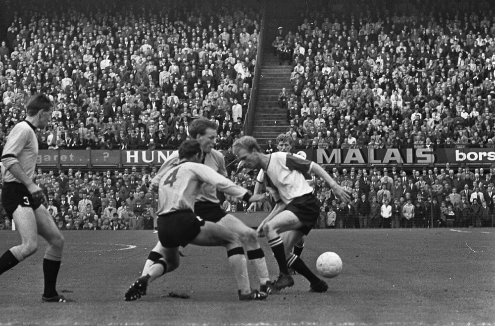 Feyenoord tegen DOS 5-0. Geels (rechts) in duel met Aarts (op de rug) en Oudenalle. Foto: Eric Koch / Anefo, Nationaal Archief (CC0).