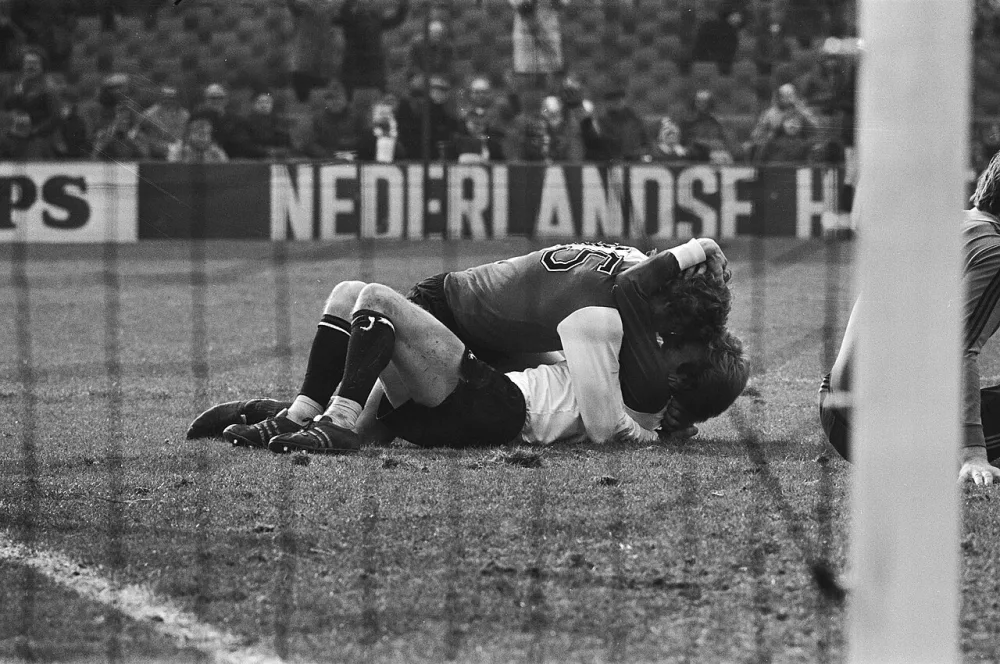 Feijenoord tegen FC Twente 3-0; Nico Jansen omhelst Kreyssen op de grond. Foto: Hans Peters / Anefo, Nationaal Archief (CC0).