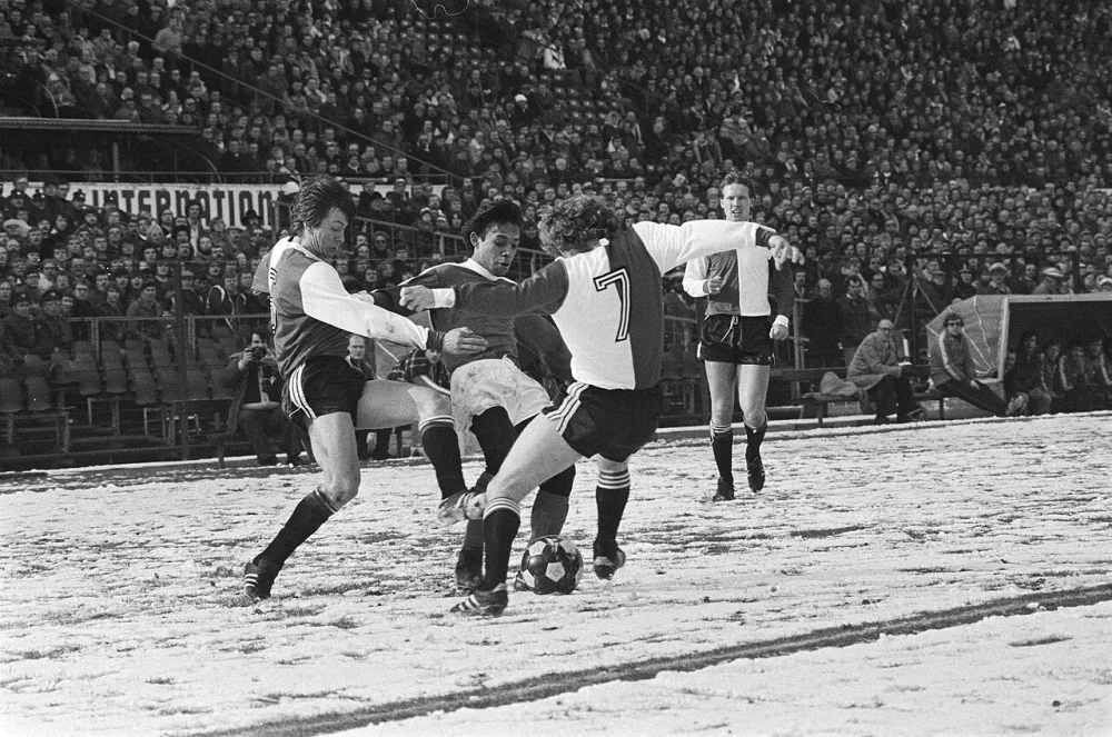 Feyenoord tegen Ajax 1-1, Tahamata (m) worstelt zich Brard (l) en Snoek door. Foto: Bert Verhoeff / Anefo, Nationaal Archief (CC0).