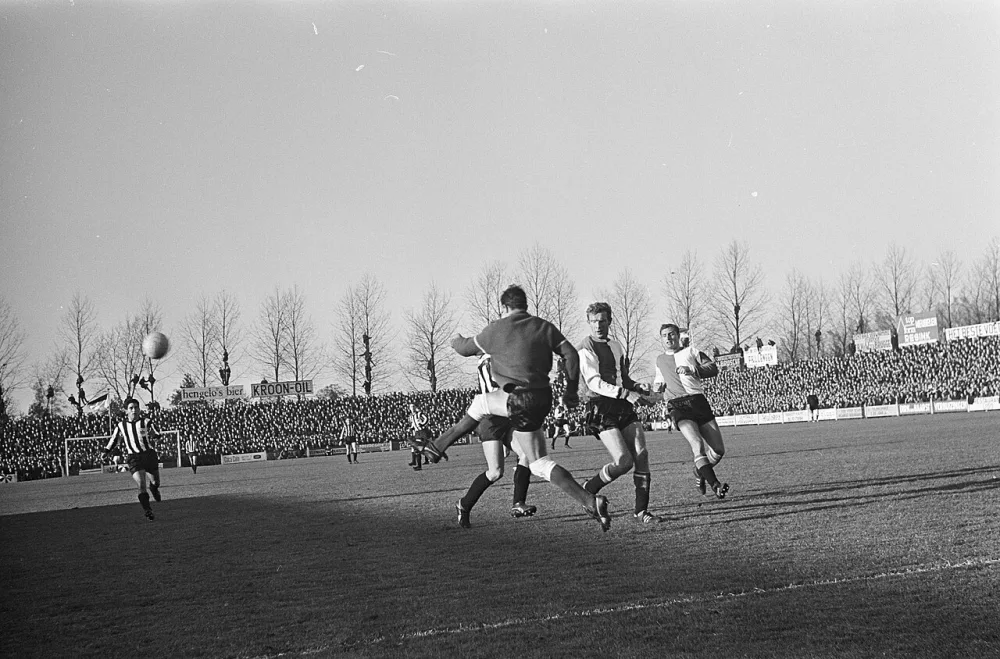 Heracles tegen Feyenoord 1-5, Keeper Eddy Pieters Graafland grijpt in. Naast hem Hans Kraay. Rechts Cor Veldhoen. Foto: Hugo van Gelderen / Anefo, Nationaal Archief (CC0).