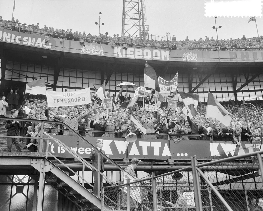 Feyenoord tegen Ajax 3-0, supporters met borden en vlaggen van Feyenoord. Foto: Herbert Behrens / Anefo, Nationaal Archief (CC0).