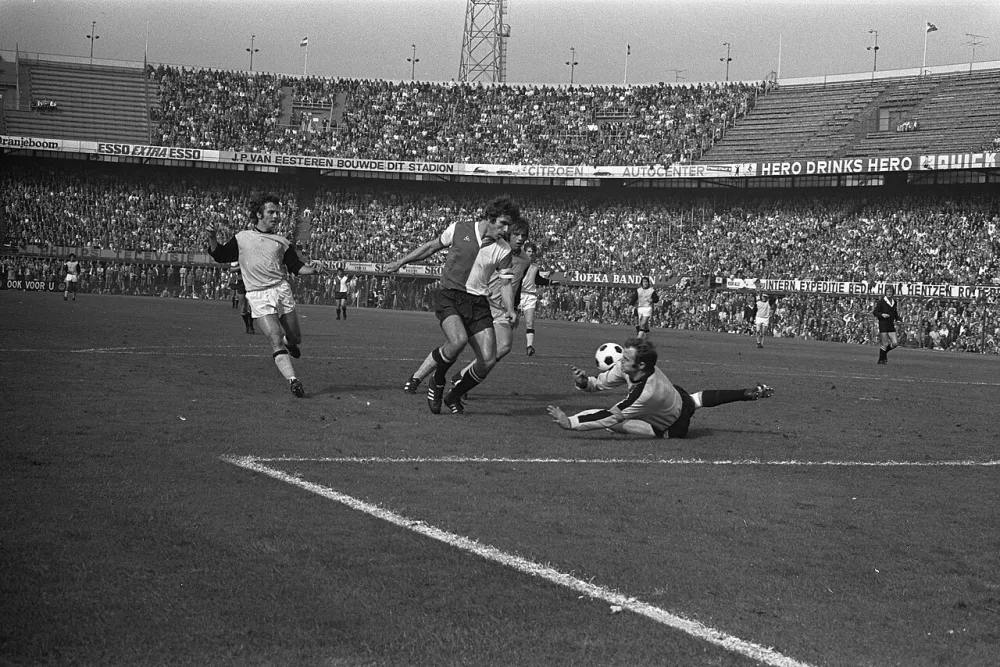 Feyenoord tegen Vitesse 4-0, Van Hanegem in actie met Vitesse keeper Gert Bals. Foto: Bert Verhoeff / Anefo, Nationaal Archief (CC0).