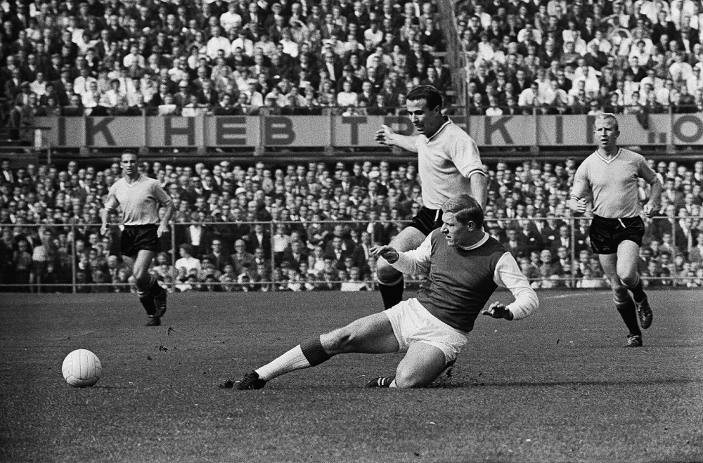 Feyenoord tegen Ajax 1-1. Frans Bouwmeester in duel met Tonnie Pronk links Kerkum rechts Henk Groot. Foto: Eric Koch / Anefo, Nationaal Archief (CC0).