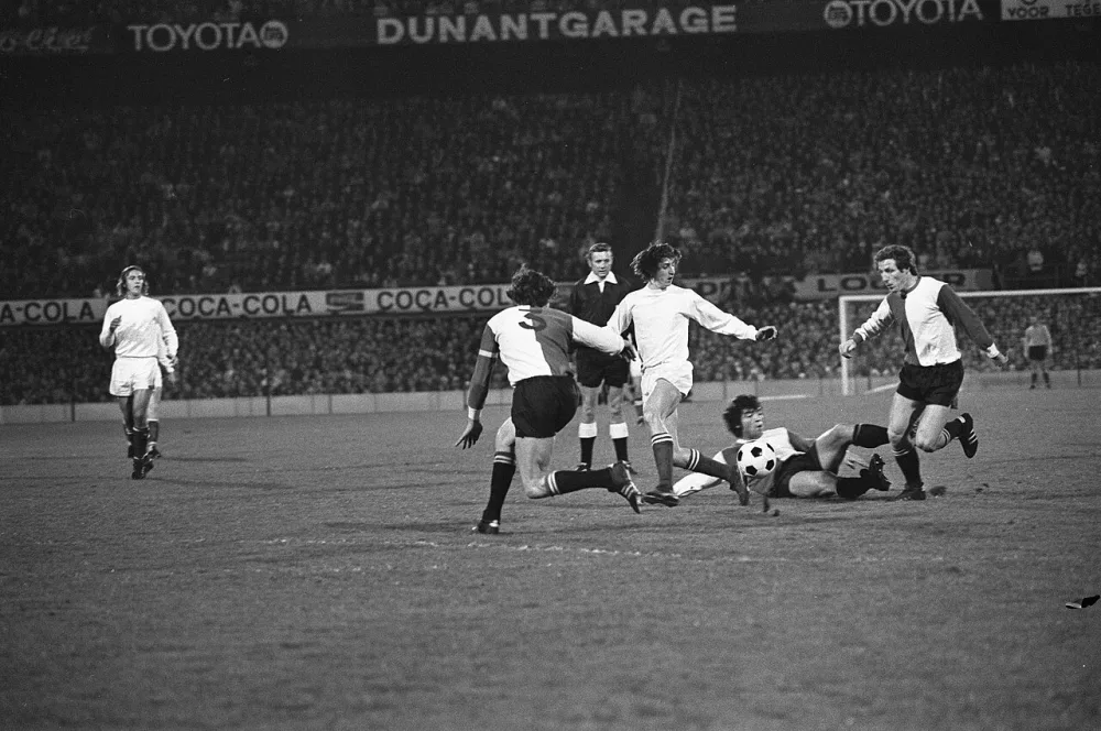 Feyenoord tegen Ajax 1-5, Cruijff in duel met Israel (link Laseroms (liggend) en Schneider (rechts). Foto: Rob Mieremet / Anefo, Nationaal Archief (CC0).
