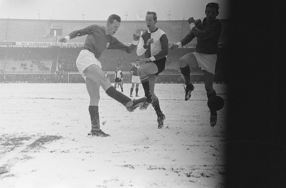 Feyenoord tegen GVAV 1-0, Henk Groot (l) in sneeuwduel Van der Hoeven (GVAV). Foto: Eric Koch / Anefo, Nationaal Archief (CC0).