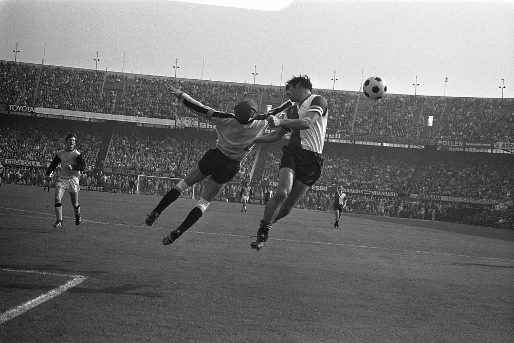 Feyenoord tegen Vitesse 4-0 . Willem van Hanegem in duel met keeper Gert Bals. Foto: Bert Verhoeff / Anefo, Nationaal Archief (CC0).