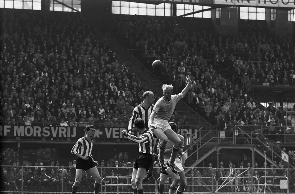 Feijenoord tegen PSV 2-2. Feijjenoordaanval Kruiver geeft kopbal, naast hem Roel Wiersma op de rug gezien Fons van Wissen. Foto: Harry Pot / Anefo, Nationaal Archief (CC0).
