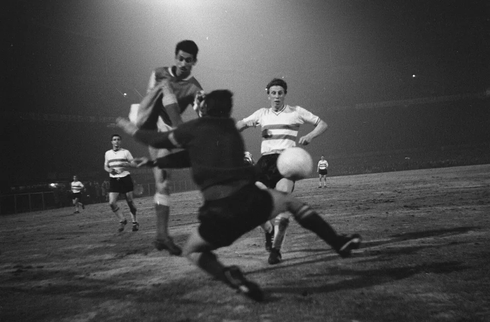 Europa Cup 1. Feyenoord tegen Reims 1-1. Keeper Eddy Pieters Graafland stopt schot van Akasbi (hoog opspringend) rechts Jan Klaassens en links Cor Veldhoen. Foto: Eric Koch / Anefo, Nationaal Archief (CC0).