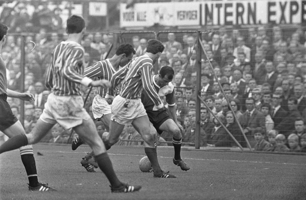 Coen Moulijn passeert drie man van Fortuna. Foto: fotograaf onbekend / Anefo, Nationaal Archief (CC0).