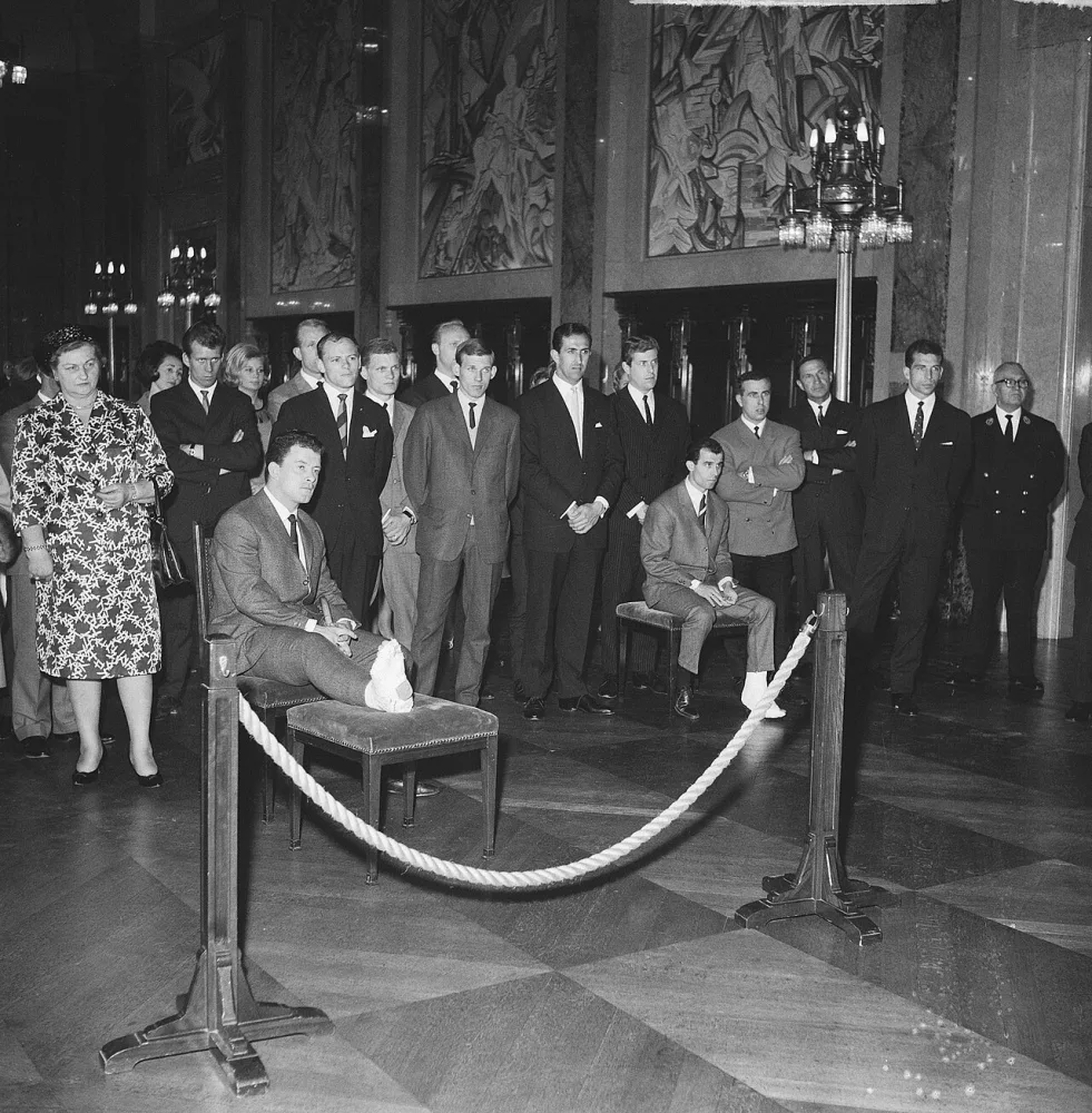 Feijenoordspelers op stadhuis ontvangen, de zwaar geblesseerde spelers Reinier "Beertje" Kreijermaat" en Coen Moulijn zitten op een een stoel met een krukje (Kreijermaat) en een krukje (Moulijn). Foto: Jan Voets / Anefo, Nationaal Archief (CC0).
