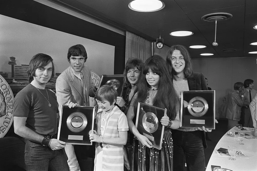 Nederlandse popgroep "Shocking Blue" arriveert op Schiphol na toernee door Amerika; v.l.n.r. R. Leeuwen , Wim van Hanegem (Feijenoord), zangeresje. Foto: Joost Evers / Anefo, Nationaal Archief (CC0).